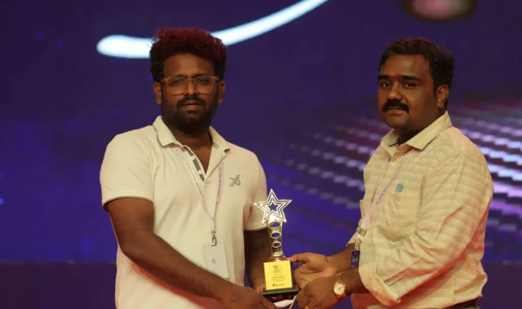 Gangatharan Anandavel receiving an award from Rajadurai