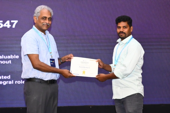 Anandakumar receiving certificate from daniel