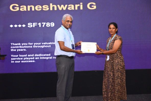 Ganeshwari Ganesan receiving an award from Daniel