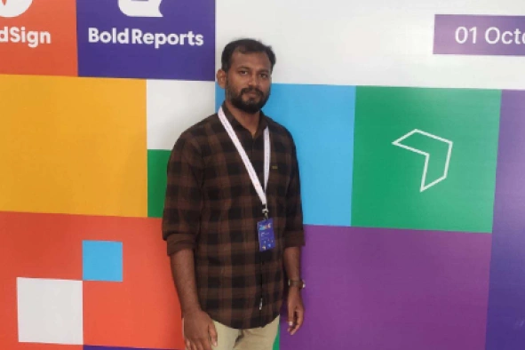 Jegan Raj standing in front of Syncfusion banner