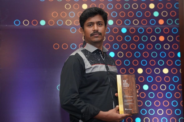 Karikalan with service award in hand