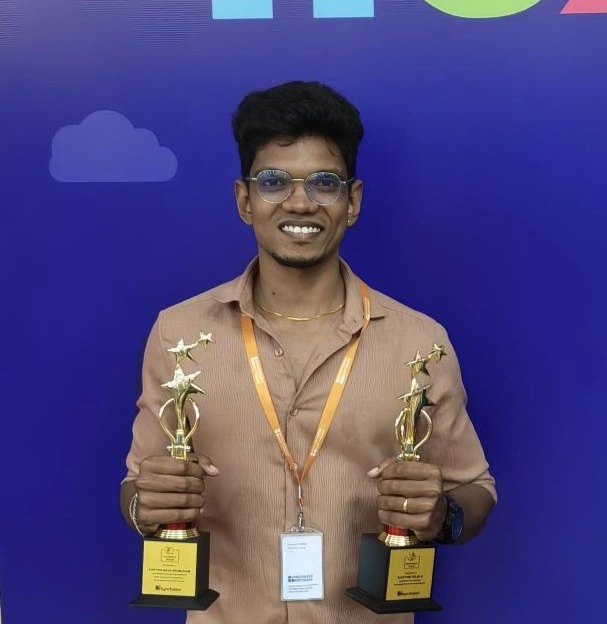Karthik Raja Arumugam standing with awards