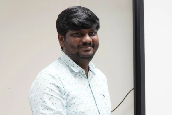 Karthikeyan standing and posing for camera