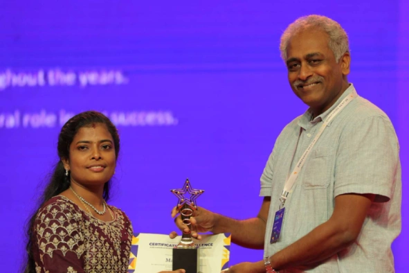 Maithiliy Karthikeyan Receiving an Award from Daniel