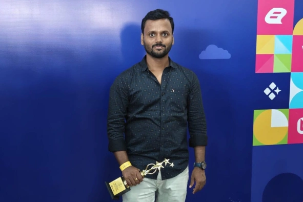 Manoj Babu holding award in his hand