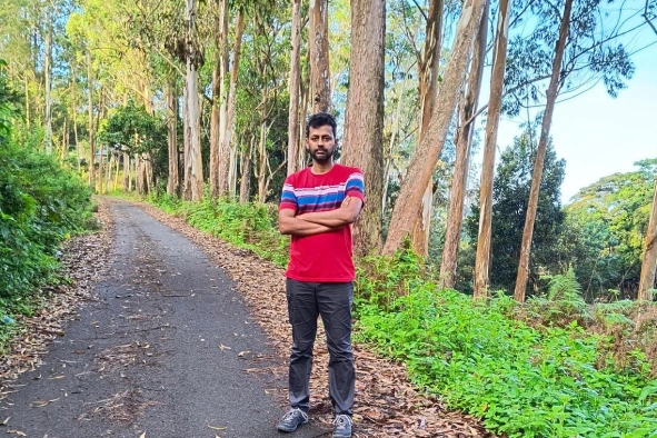 Meikanda standing in a valley surrounded by trees