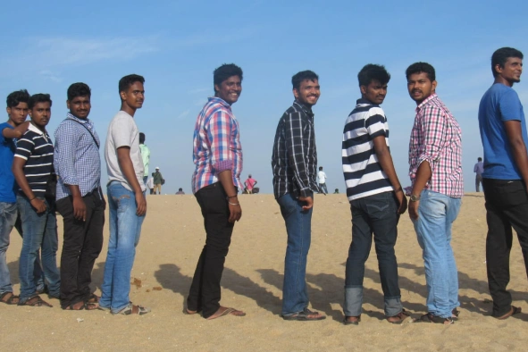 Satheeskumar sekar with team members in beach sand