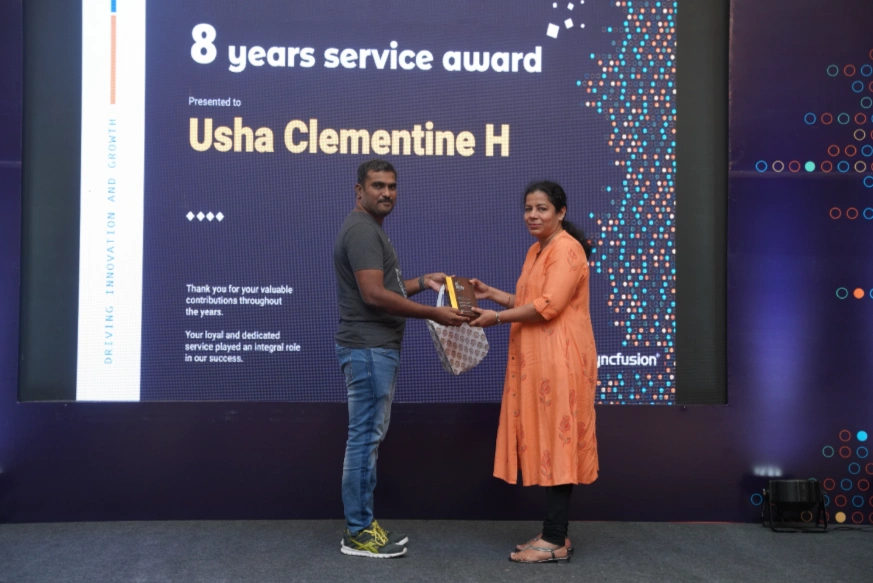 Usha Clementine Henry receiving an award from Balaji Murugesan