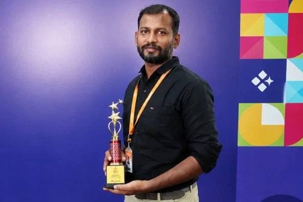 Jegan Raj holding award in hand